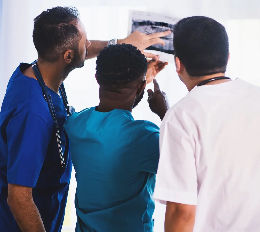 Three dental professionals reviewing an X-ray together